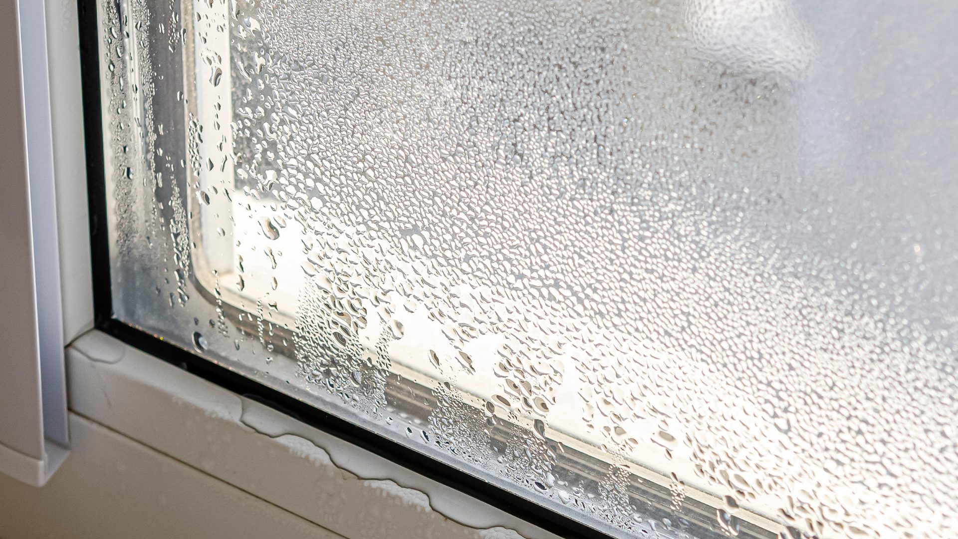Leaky window frame in a Peoria home showing signs of water damage and air drafts.